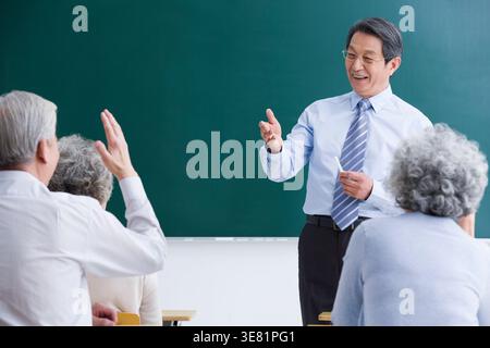 Senior Chinese professor teaching senior students in classroom Stock Photo