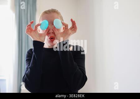 Funny portrait with dyed eggs, joyful Easter concept and creative home activity. Stock Photo
