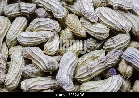 Top view of freshly boiled peanuts in shell at a Thai market. Natural brown texture of organic groundnuts, ideal for healthy snacks and agriculture. Stock Photo