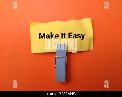 The text Make It Easy is written on a yellow sticky note. Stock Photo