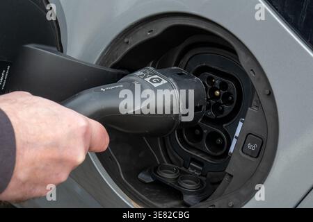 FLINTSHIRE, WALES, UK, 22 MARCH 2026: Hand Inserting Type 2 Electric Vehicle Charging Cable into Car Inlet Port Stock Photo