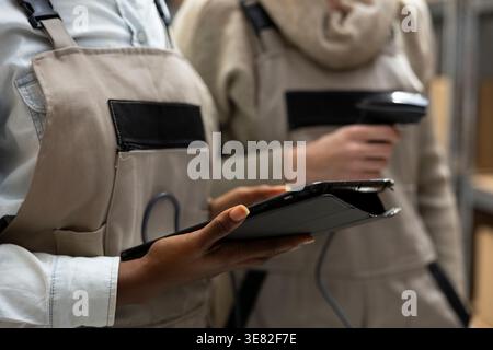 Bar code scanning for logistics handled by group of workers who oversee inventory management, product distribution and crate stacking for efficient delivery. Import export packages. Stock Photo