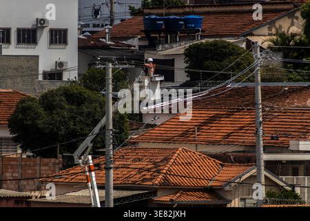 Marilia, SP, Brazil, April 10, 2026. A worker from the electric utility company CPFL, wearing a white hard hat, orange reflective vest, and safety glo Stock Photo