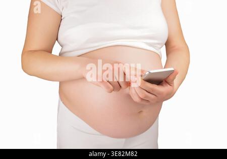 a pregnant woman using a cellphone against a white background Stock Photo