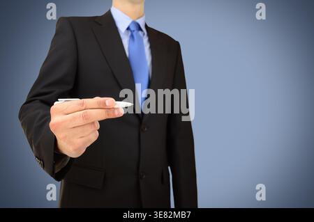 businessman writing ideas on a transparent wipeboard against a blue background Stock Photo