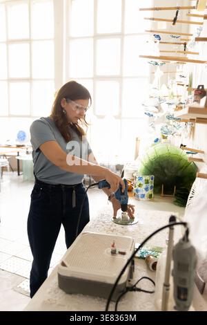 Woman artisan working on decor objects, standing in workshop studio Stock Photo