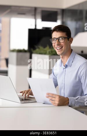 Lawyer sitting at desk with contract paper and laptop Stock Photo