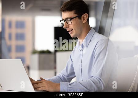 Hispanic professional man typing on laptop keyboard in office Stock Photo