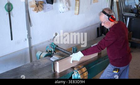 Senior man working wood with jointer machine Stock Photo