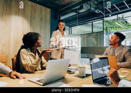 Asian project manager celebrating results with black colleagues Stock Photo
