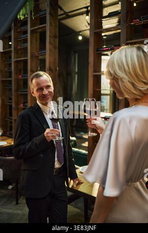 Middle Aged Couple Toasting with Red Wine during Business Dinner Stock Photo