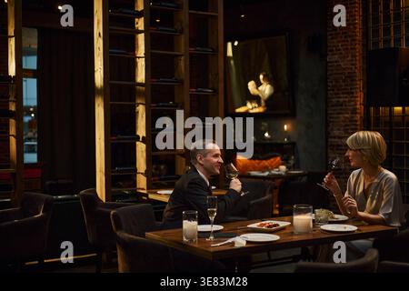 Middle Aged Couple Drinking Wine during Upscale Dinner Date Stock Photo