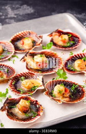 Cooked scallops with parsley on a baking sheet Stock Photo