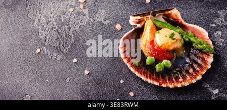 Cooked scallops with vegetables on a dark background Stock Photo