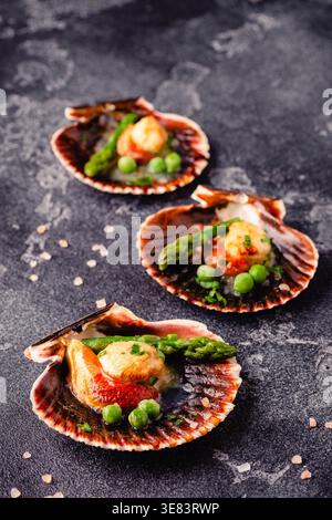 Cooked scallops with vegetables on a dark background Stock Photo