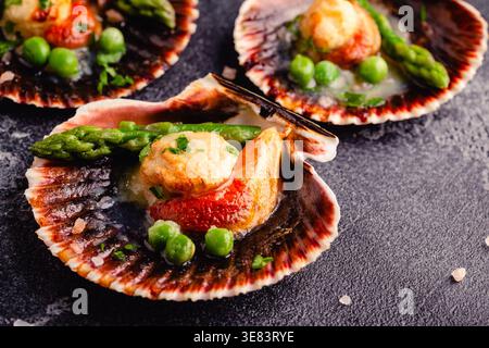 Cooked scallops with vegetables on a dark background Stock Photo