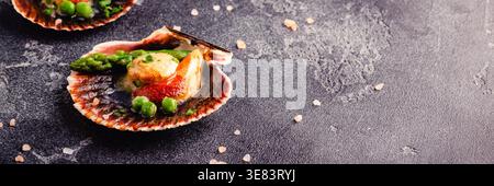 Cooked scallops with vegetables on a dark background Stock Photo