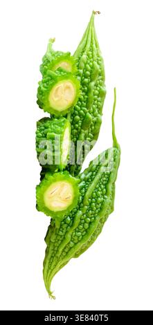 Side view of green bitter gourd or bitter melon with slices in circle shape in small pile is isolated on white background with clipping path. Stock Photo