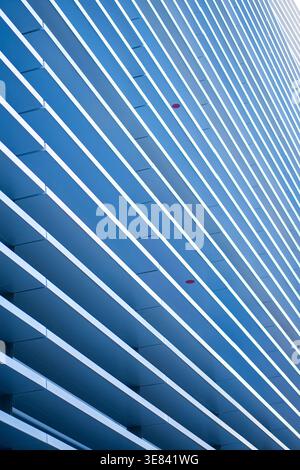 Abstract building exterior rhythmic pattern of blue and white horizontal lines Stock Photo