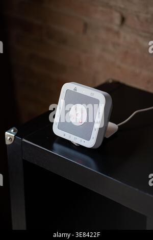 Modern smart home security keypad on a dark table with touchscreen interface Stock Photo