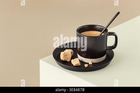 Cup of coffee with brown sugar cubes on duo coloured background Stock Photo