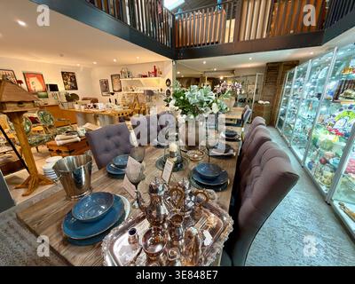 Styled dining table display inside Hudson’s Home & Antiques in Stratford-upon-Avon, surrounded by curated interiors showrooms and homeware. Stock Photo