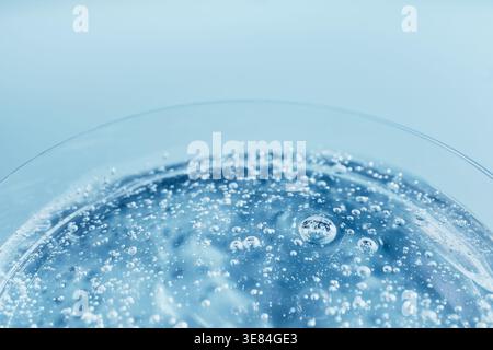 Bubbles rising in sparkling blue liquid, forming an abstract and refreshing background Stock Photo