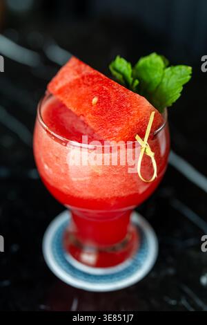 Watermelon slush cocktail with mint garnish in stemmed glass Stock Photo
