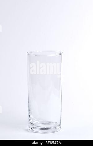 A tall empty clear glass standing on a white background. Stock Photo