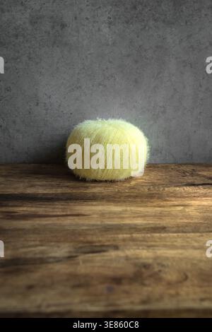 Knitting with soft fluffy yarn in blue and yellow colors, handmade craft close-up. Two fluffy yarn balls, one blue and one yellow. Cozy handmade. Stock Photo