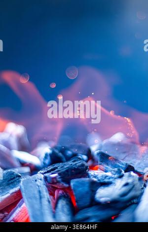 Summer Barbecue: Glowing Charcoal with Flames and Sparks Close Up on Dark Background Stock Photo