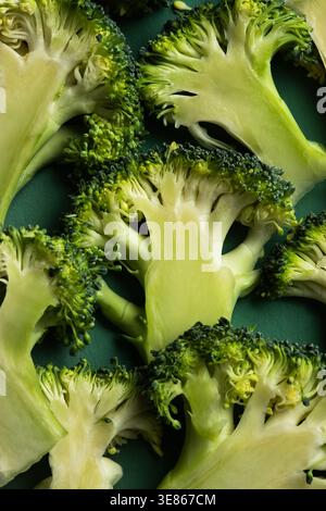 Macro close-up of fresh broccoli florets arranged on a dark green plate, highlighting crisp texture, vibrant color, and healthy vegetable ingredients Stock Photo
