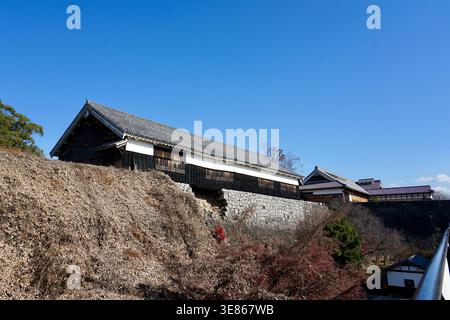 Historic Japanese Castle Tower Against Clear Blue Sky With Stone Walls And Traditional Roofs Stock Photo