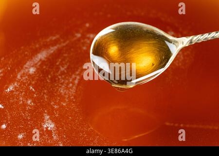 Spoon filled with golden maple syrup. Stock Photo