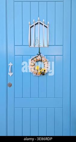 Easter wreath on blue front door with spring holiday entrance decor Stock Photo