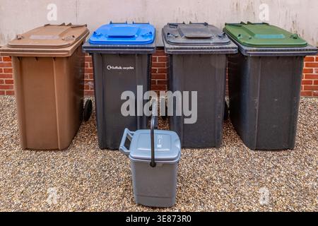 Recycling & waste bins. Suffolk, UK. Brown - garden waste, blue - containers, black - general rubbish, green - paper & card,  grey caddy- food waste. Stock Photo