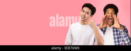 Smiling Asian Man Doing Call Me Gesture in Fun Studio Background Stock Photo