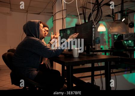 Hackers team planning cyberattack on internet, talking about malicious software code to crack firewall encryption. Online criminals breaking into database, information. Internet fraud. Stock Photo
