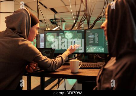Cybercrime, criminals hacking server, stealing analytics data, developers programming illegal firewall. Hackers cracking computer system password at night time, corporate information leak Stock Photo
