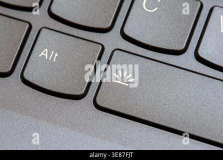 Macro close-up of a modern laptop keyboard backlight control key with illumination symbol next to Alt button, black notebook computer keys in angled v Stock Photo