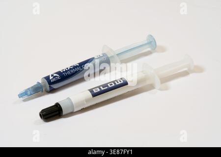 Two branded thermal paste syringes for CPU and GPU cooling isolated on white background, close-up product shot of computer hardware maintenance suppli Stock Photo