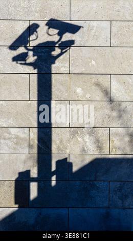 Shadow of surveillance cameras on a wall as a symbol for monitoring, security and privacy concerns. Concept, Wall, Background, Camera, Shadow vertical Stock Photo