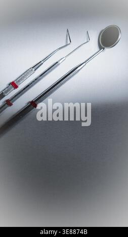 Dental tools on white background, mirror and probes for oral checkup, clean vertical composition Stock Photo