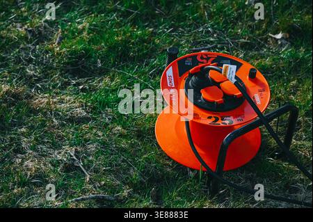 Riga, Latvia - April 11, 2026:Portable outdoor cable reel with multiple power outlets placed on grass. Ideal for garden work, construction, and home i Stock Photo