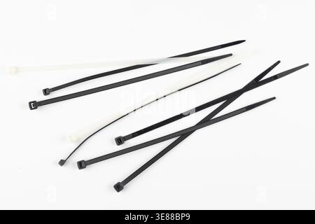 Several black and white cable ties lie loose on a white background Stock Photo