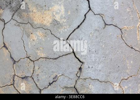 Close-up of multiple small cracks and deep fissures on grey painted concrete foundation exterior house wall in poor condition, Quebec, Canada Stock Photo