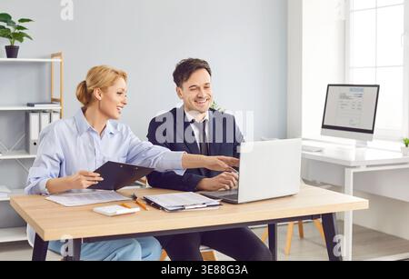 Smiling colleagues working together on business project demonstrating effective teamwork in office. Stock Photo