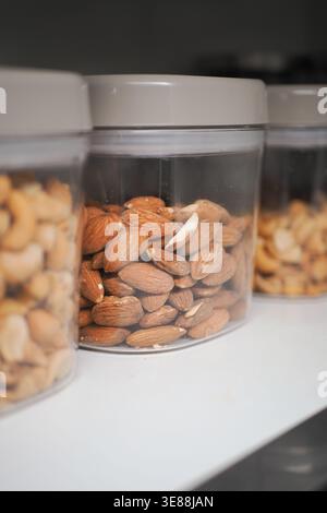 Different types of nuts in clear containers on a shelf Stock Photo