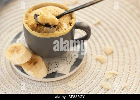 cupcake in a mug with banana pieces. Banana cupcake on a light background.  Stock Photo