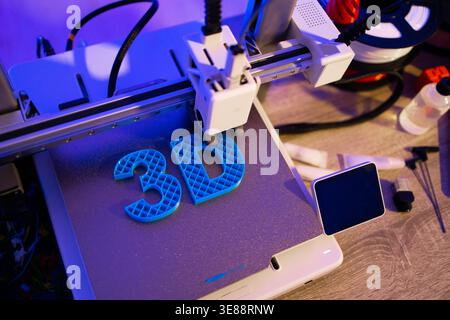 3D Printer Creating Blue Letters Stock Photo